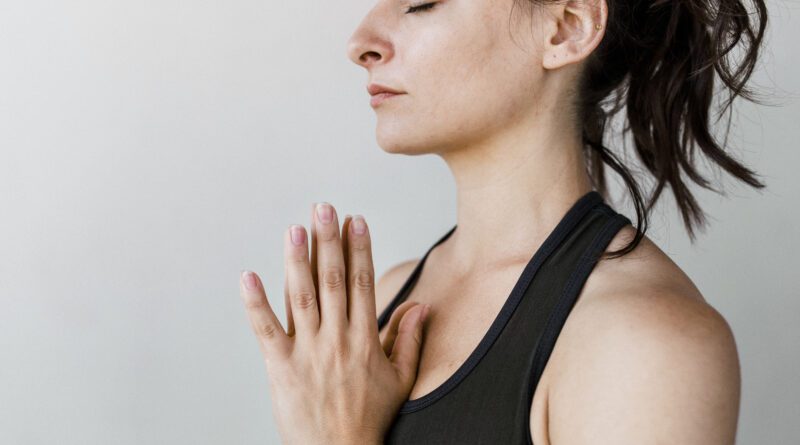 Sportliche Frau in Anjali Mudra Pose