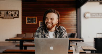 man in black and white plaid dress shirt using silver macbook