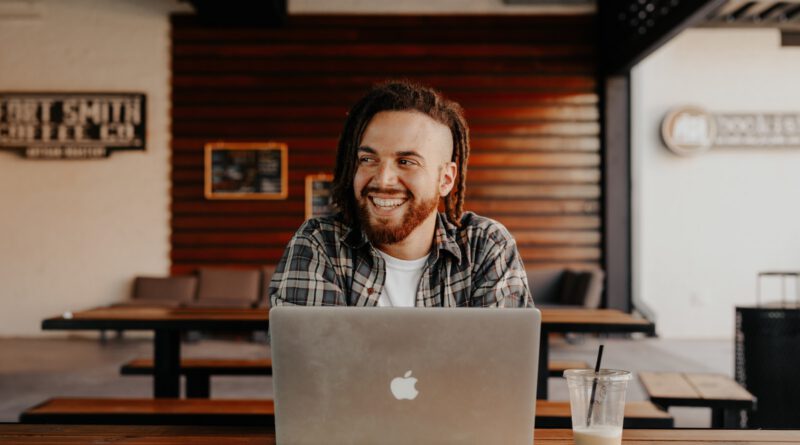 man in black and white plaid dress shirt using silver macbook